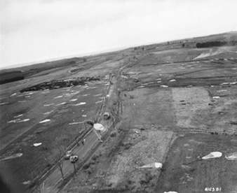 Photo:  SC415381 - BRIEALF, GERMANY  C-47s of the 101st Airborne Division drop supplies on the 4th Infantry Division Sector. This became necessary when rains and early thaw made roads impassable in this area. The supplies consisted of rations, gas, and ammunition. 13 February 1945.